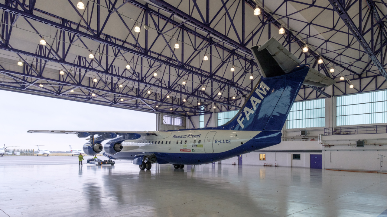 FAAM research aircraft in empty hangar facing outward towards open doors